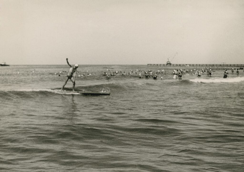Précurseur des vagues : Avec sa planche de sauvetage de plus de trois mètres de long, Uwe Drath a surfé les premières vagues au large de Sylt en 1952. © Archives Drath 